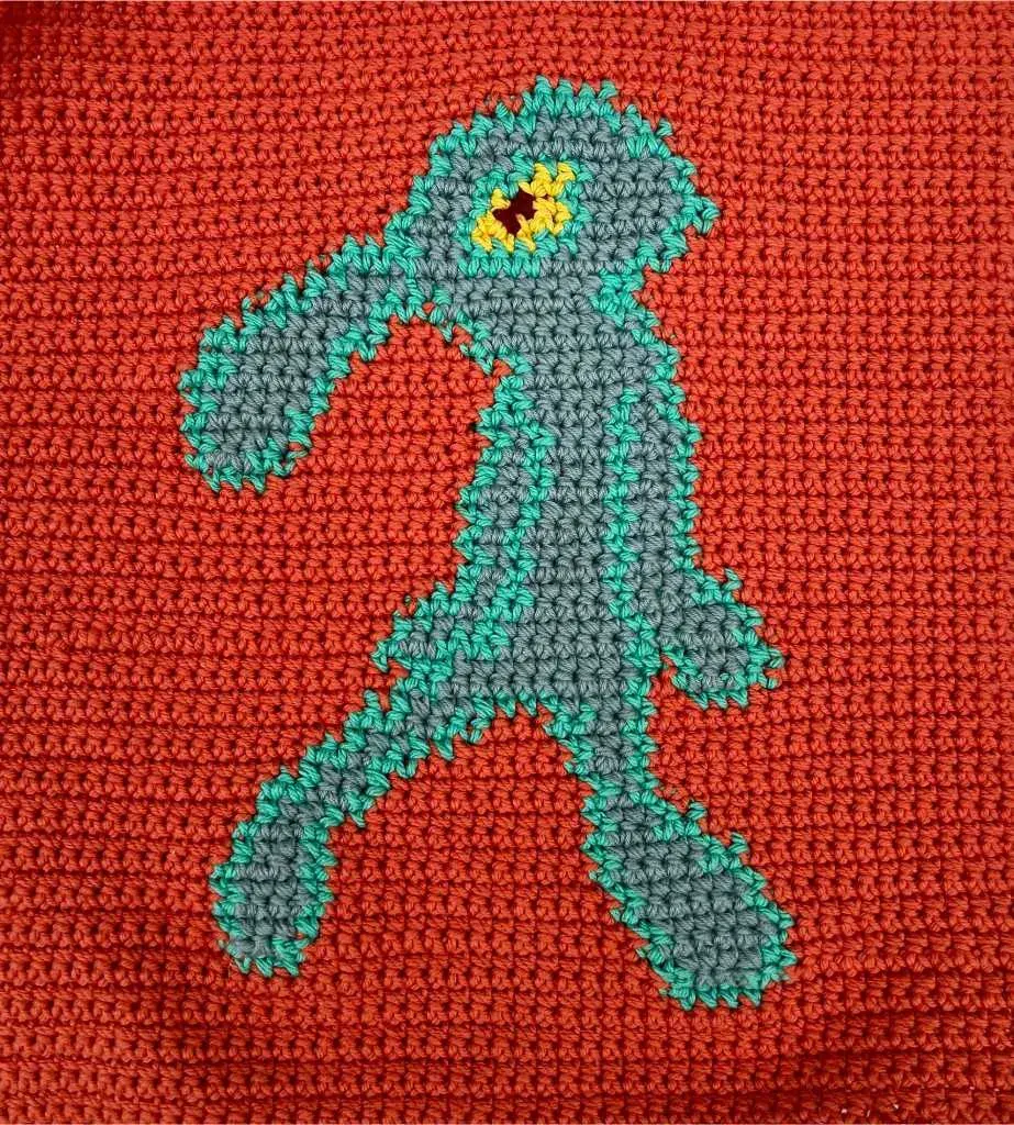 a crochet tapestry with a vibrant orange background and a groovy blue squid