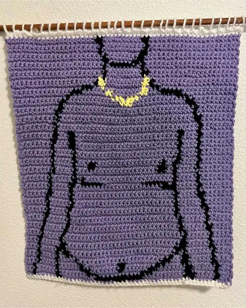 a crochet tapestry with a purple background and a line drawing of a person wearing a small gold chain with top surgery scars